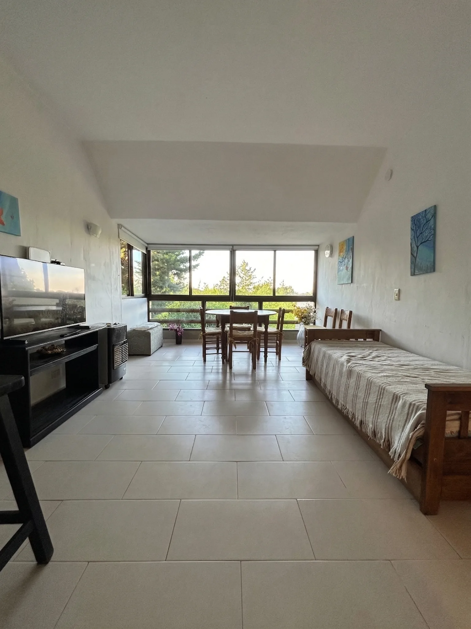Living comedor luminoso de Casita de la Colina, con grandes ventanales hacia el verde